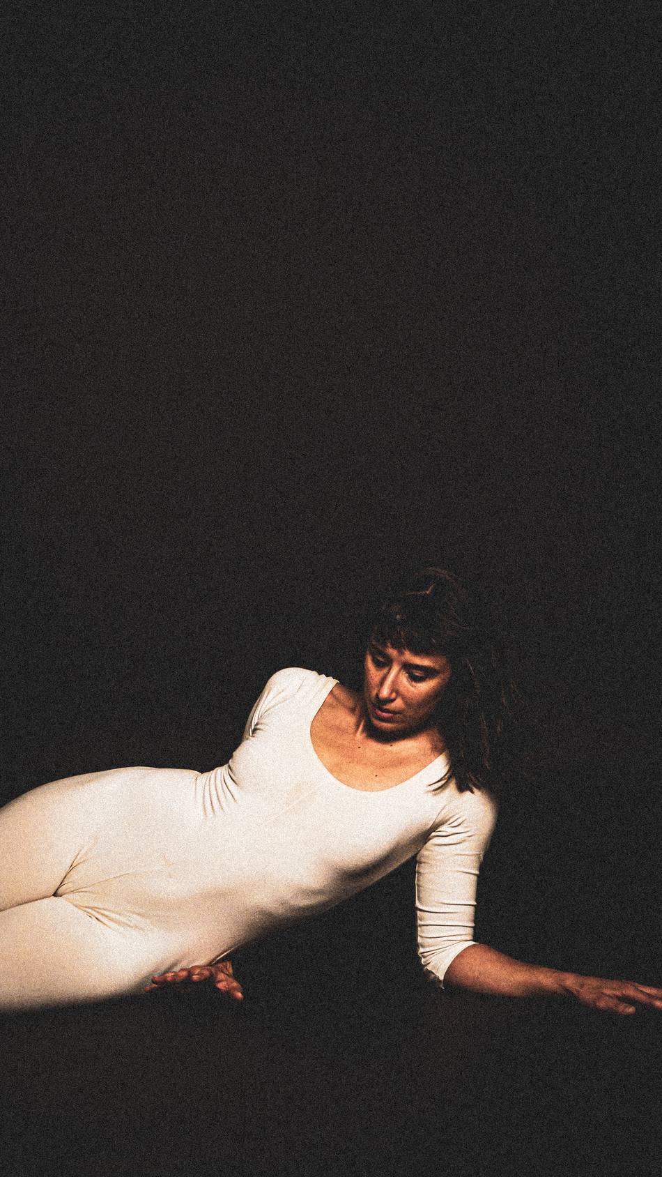 Dancer reclined, reaching across the frame
