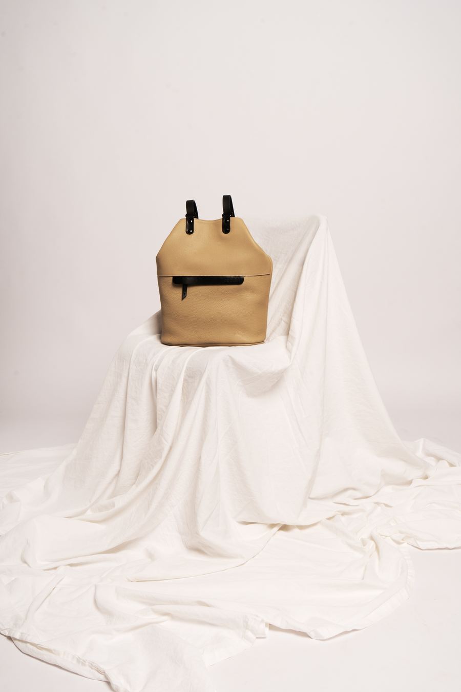 Leather backpack on draped linen