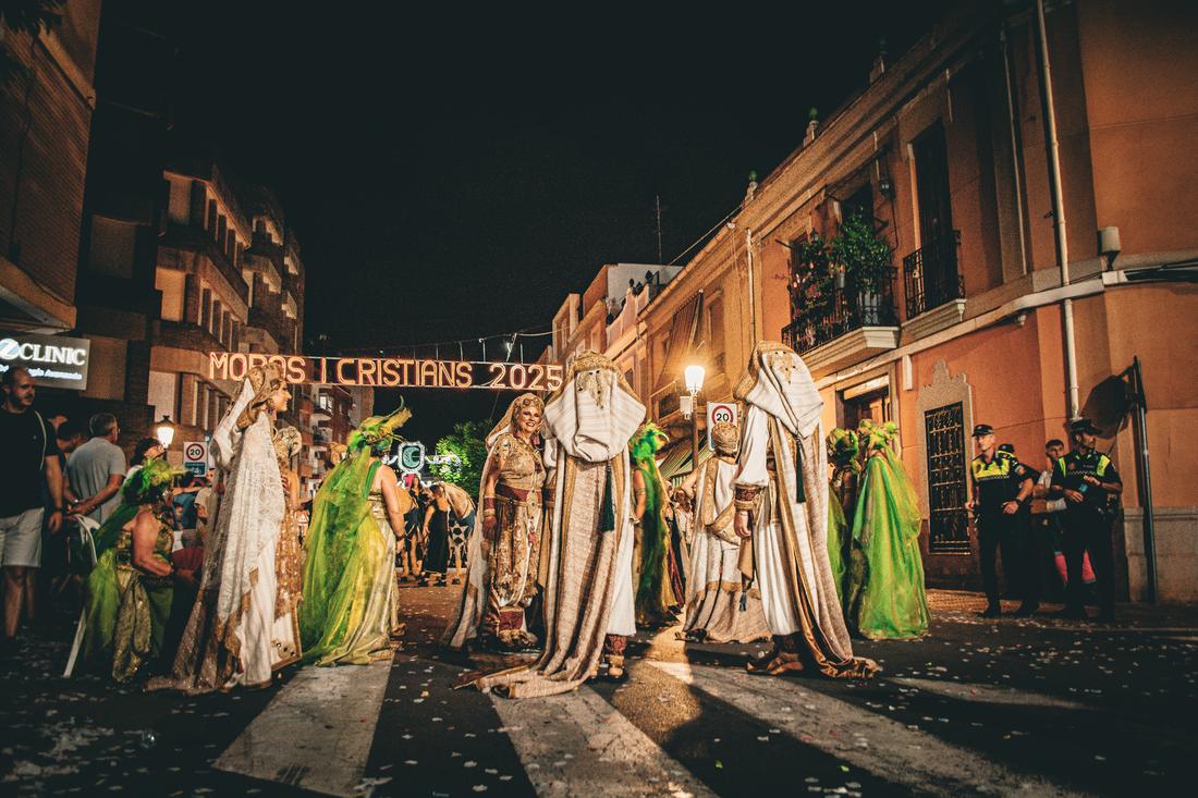 Costumed procession beneath the festival's illuminated arch