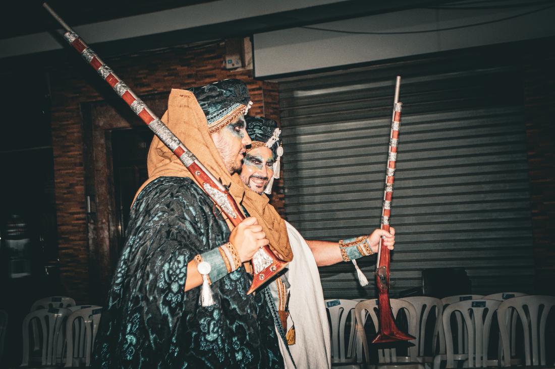 Two Moros holding ornate rifles in profile
