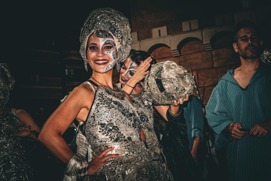 Woman smiling close to another woman's ornate headdress