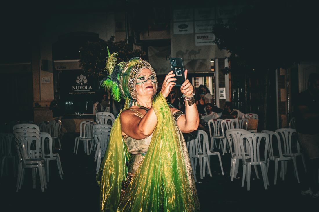 Woman in green cape taking a photo of herself