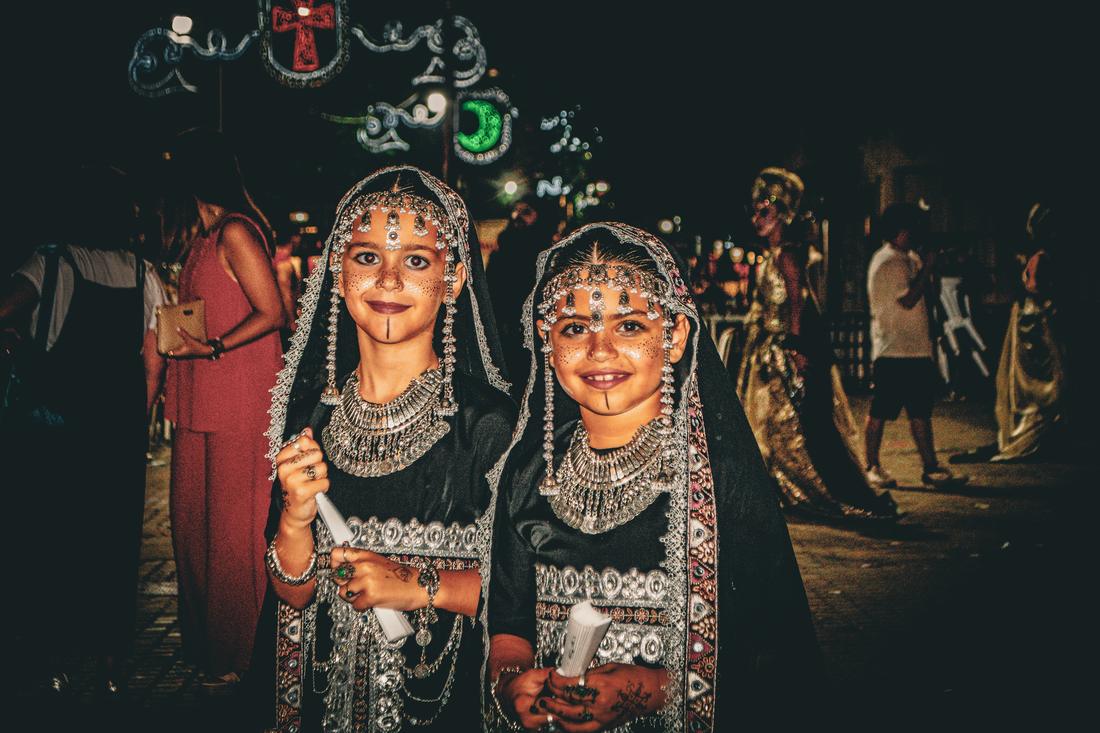 Two young girls in ornate Moorish costume smiling
