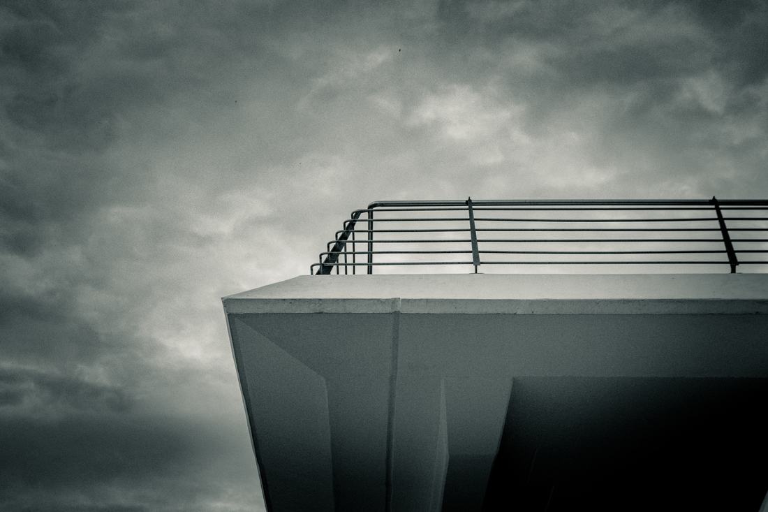 Concrete building corner against a stormy sky