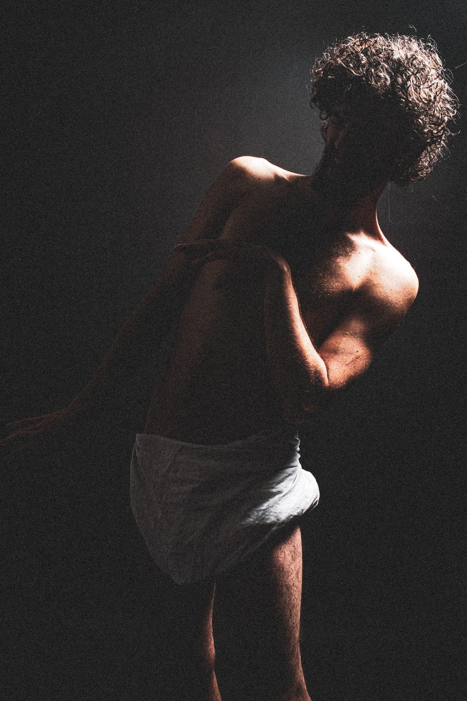 Silhouette of a man in profile, arm folded across his chest